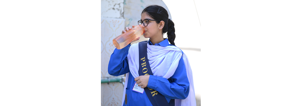 Azia Moin, a student at Islamabad Model College for Girls, drinks water from her refillable water bottle
